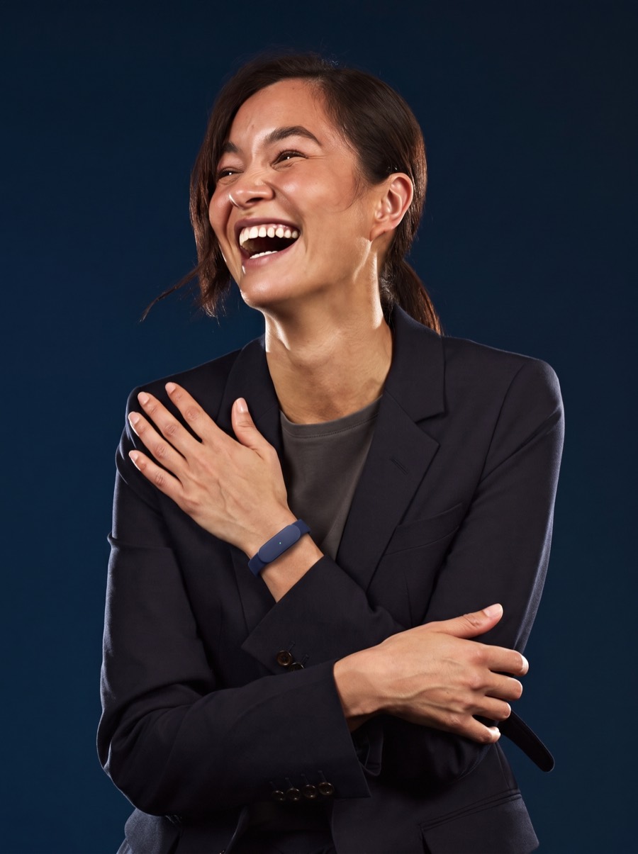 A leader laughing mid-conversation, wearing the slim navy Larkin wristband