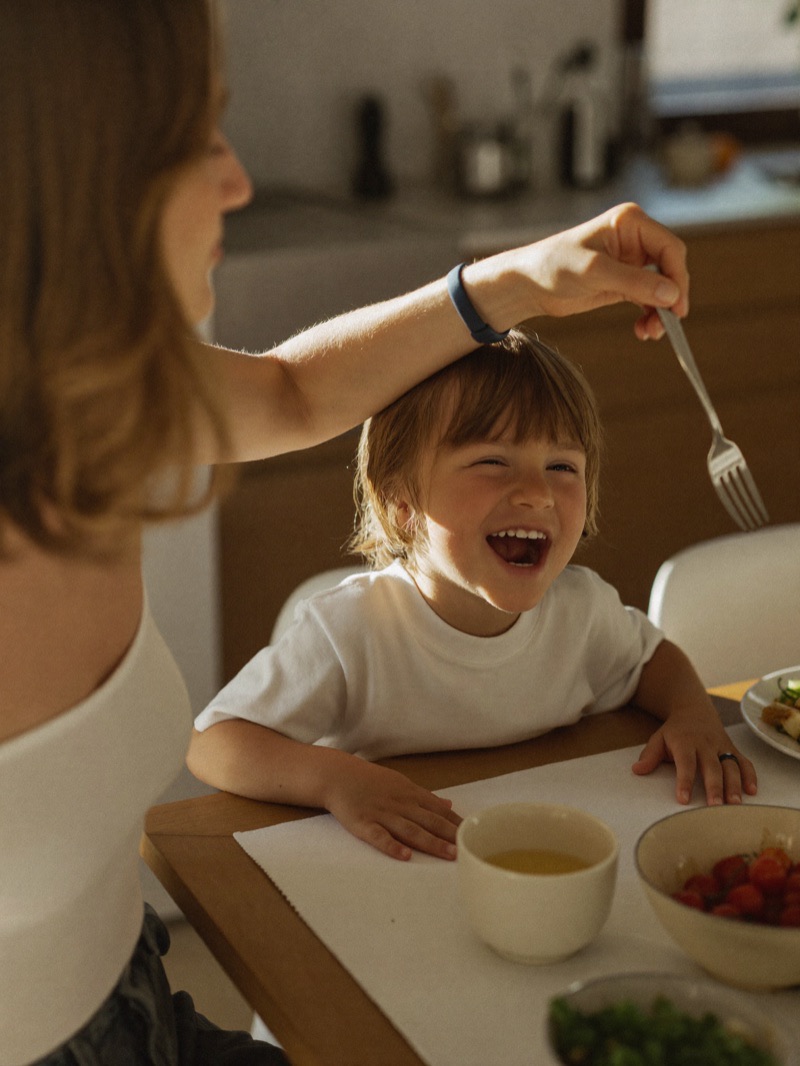 A parent and laughing child at the kitchen table
