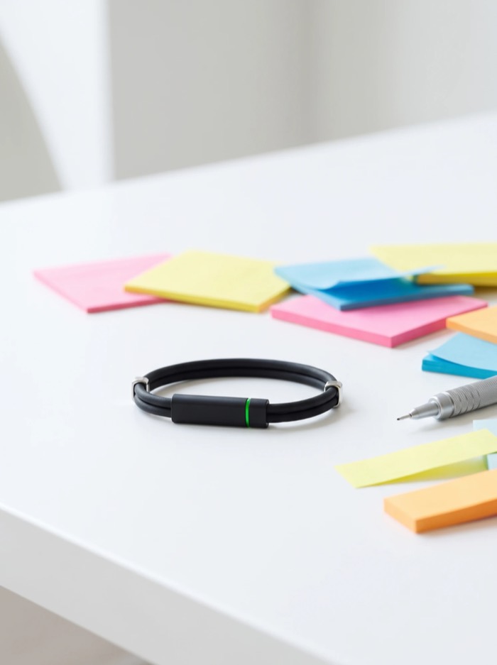 The black band on a white desk beside sticky notes