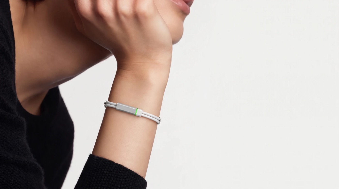The white Larkin band on a wrist, its green ring lit