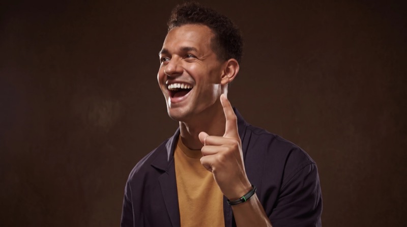 A man mid-idea, pointing up and laughing, the Larkin band on his wrist