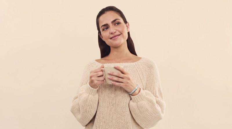 A woman holding a warm mug, lost in thought, the Larkin band on her wrist