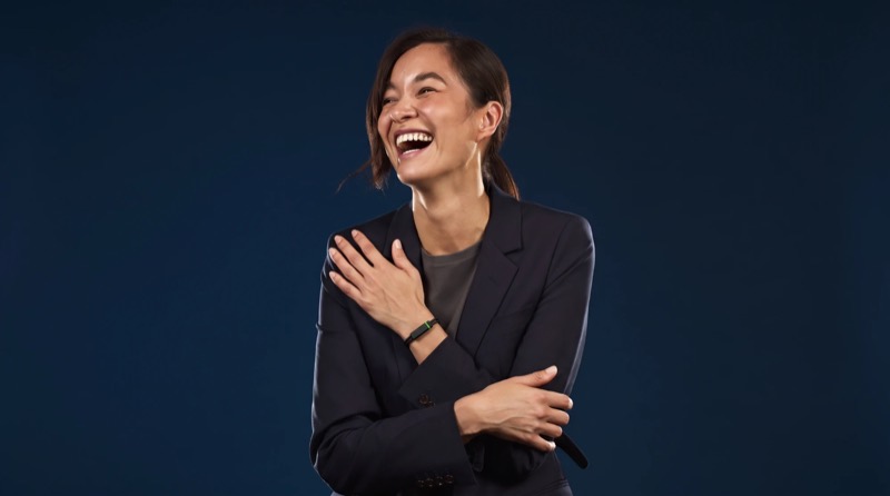 A leader in a navy blazer laughing, the Larkin band on her wrist